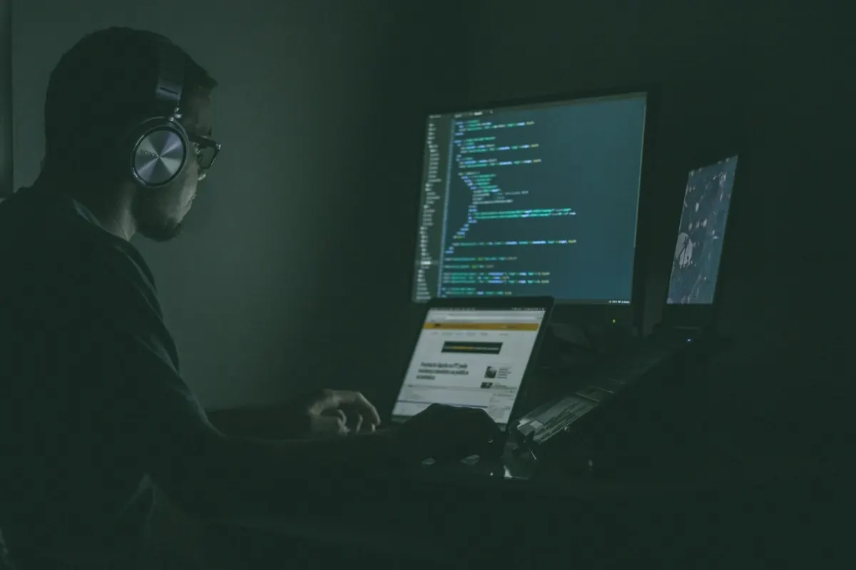 Especialista trabajando frente a pantallas con código